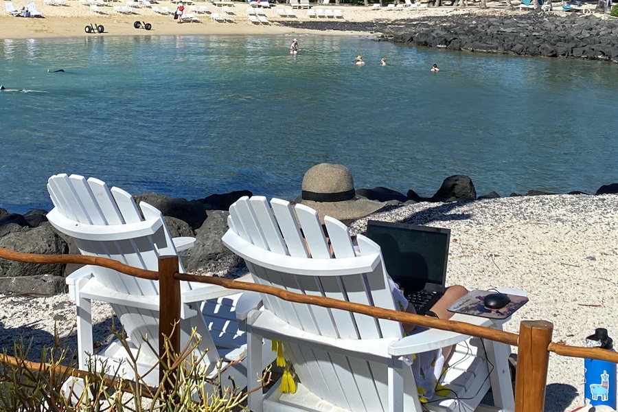 Woman working on laptop at beach at Fairmont Orchid Big Island Hawaii
